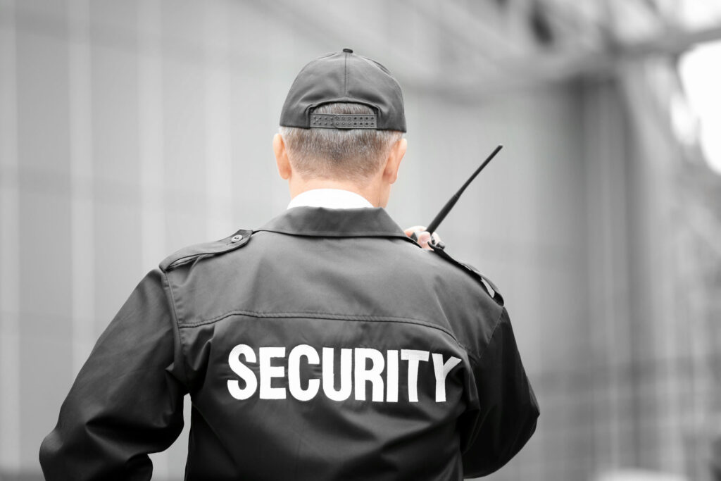 Male security guard using portable radio outdoors GUETTA Seguridad Privada